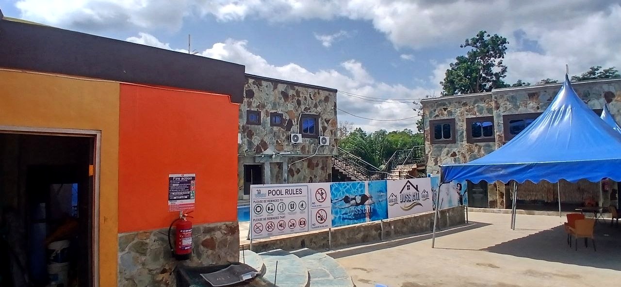 Courtyard beside an orange building, with pool rules and a blue canopy.