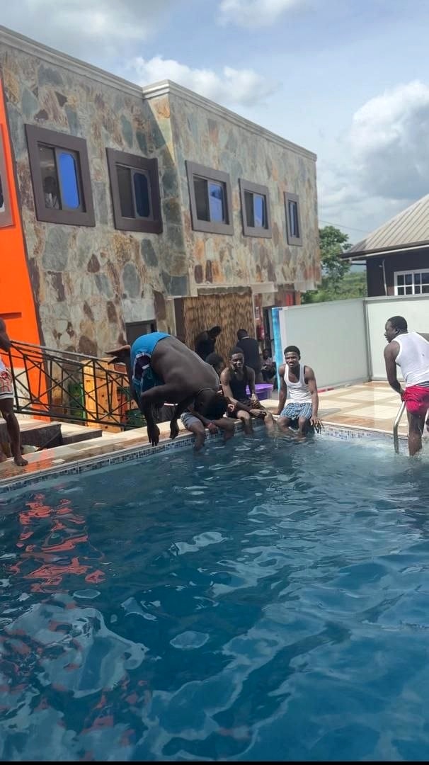 Guests in the swimming pool beside the guest-house building.
