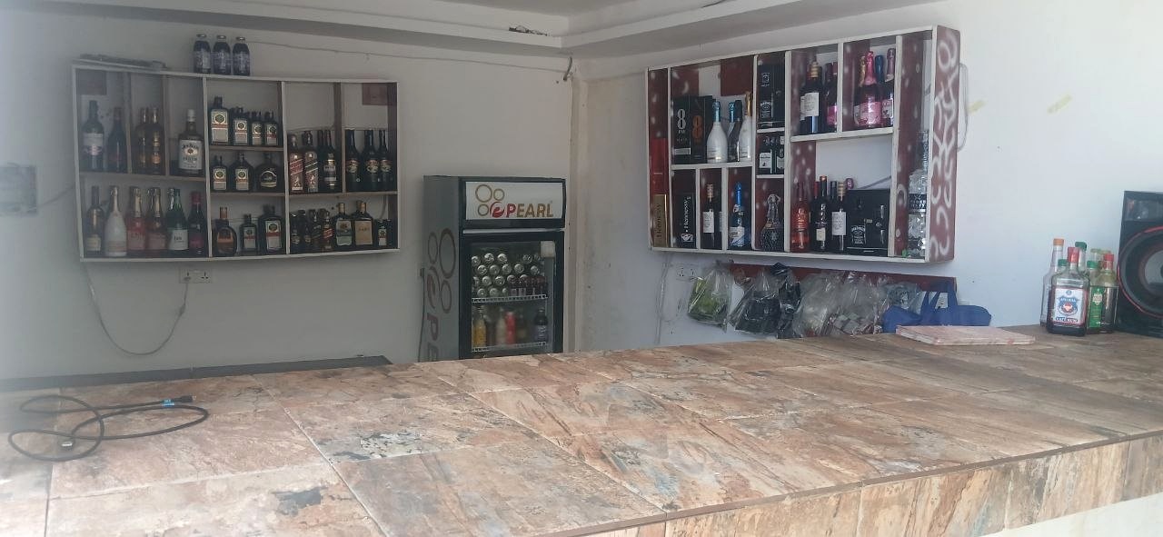 Pub interior with a counter, bottle shelves and wall displays.